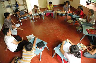 Class in Progress Students and teachers sit on the floor during a class